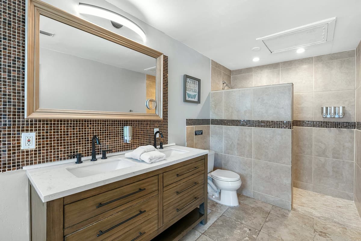 The ensuite bathroom features a double vanity, soaking tub, and warm tile accents.