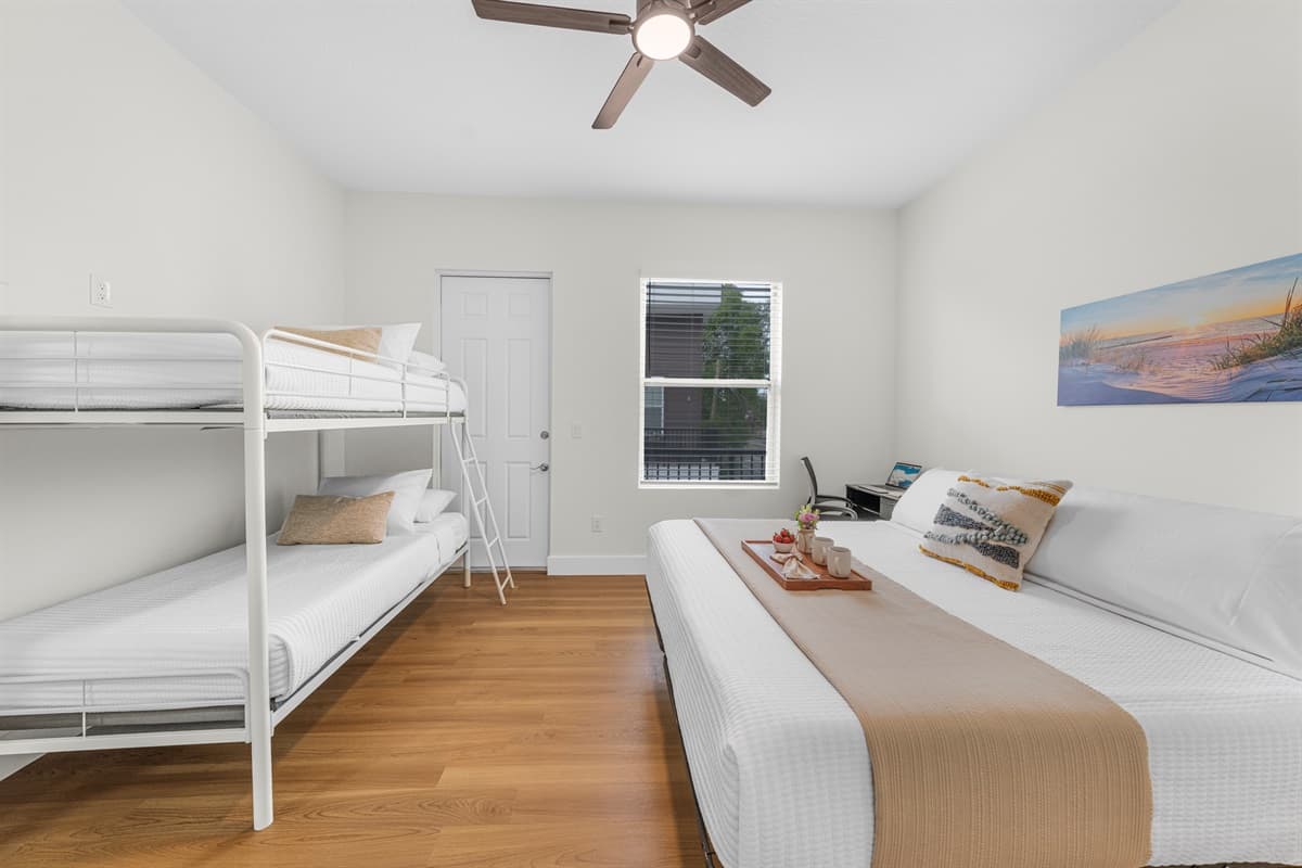 Spacious bedroom with a queen bed and bunk beds—perfect for families or groups, offering comfort and flexible sleeping arrangements.