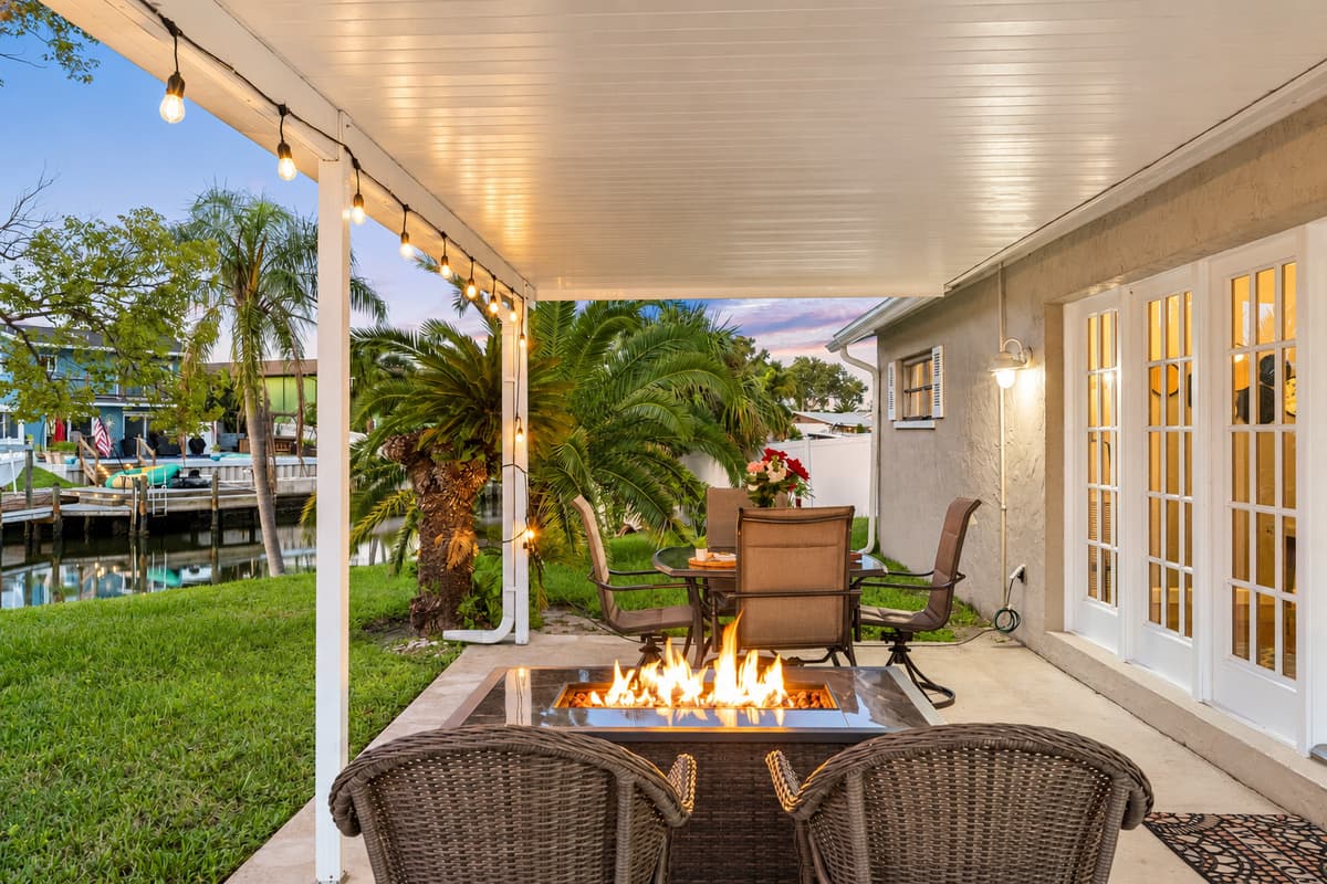 String lights and a glowing fire pit create an inviting atmosphere that makes this patio the perfect spot for cozy nights outdoors.