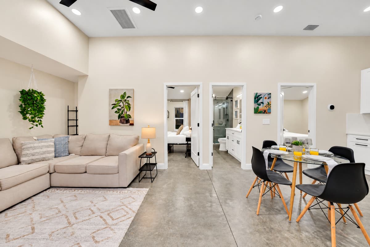 Living room and dining table, all in one room. Cook, eat and collapse without crossing the house. It works as a self-contained wing for one family, or as the overflow lounge when the main house gets loud.