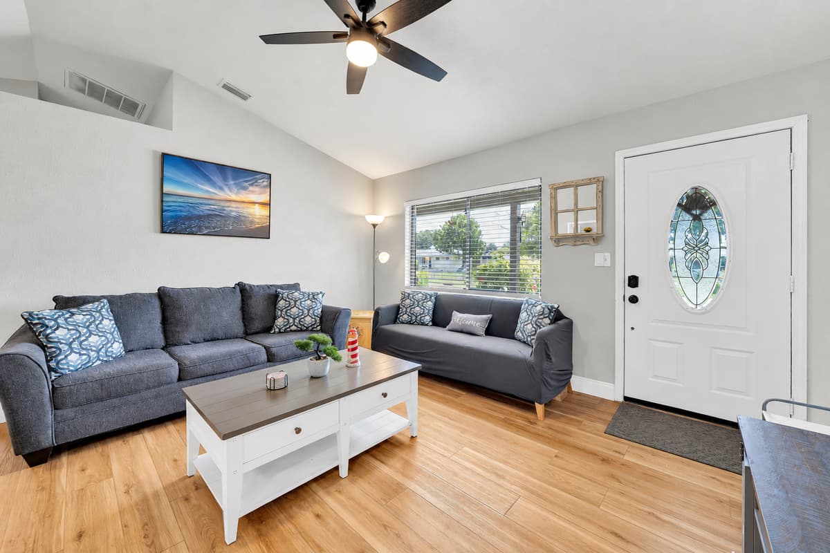 Drop the bags here and the week begins. Bright open living room, sofas facing each other for actual conversation, and a front door that opens with a code the moment you arrive — no desk, no line, no waiting.