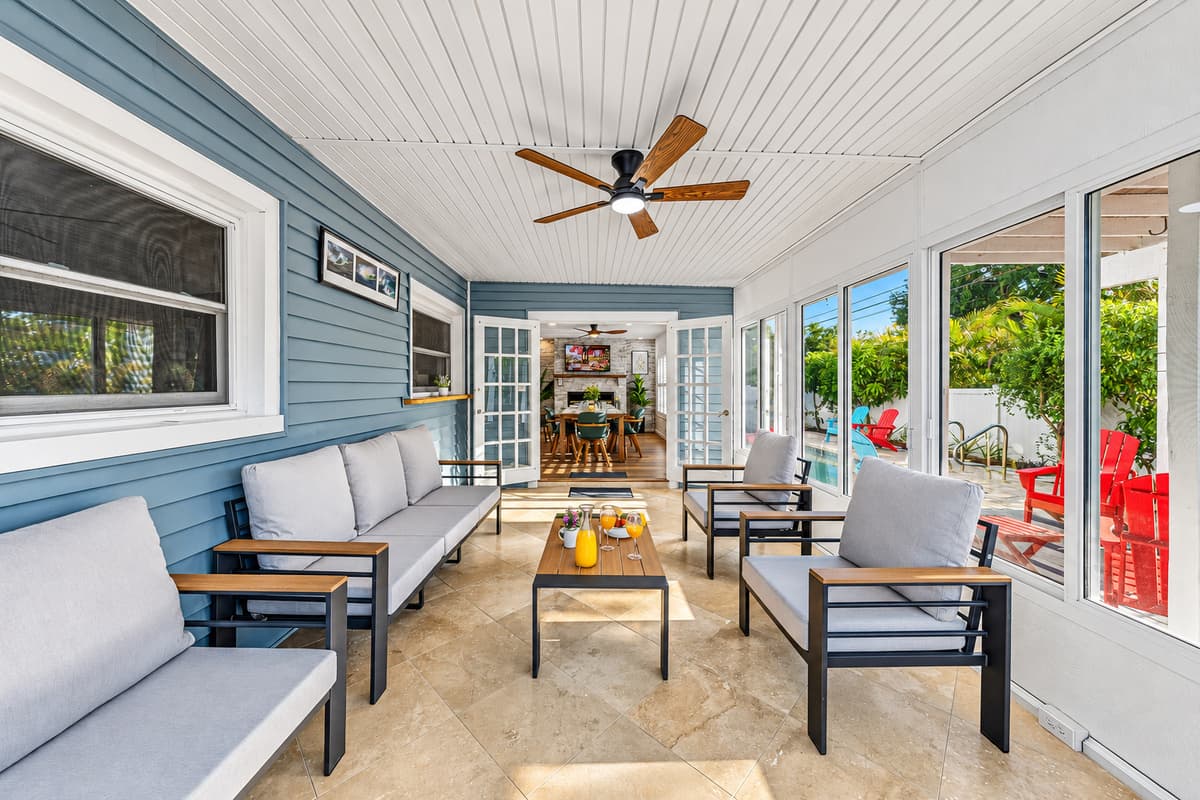 Spacious sunroom with multiple seating areas, perfect for relaxing or gathering with friends and family 