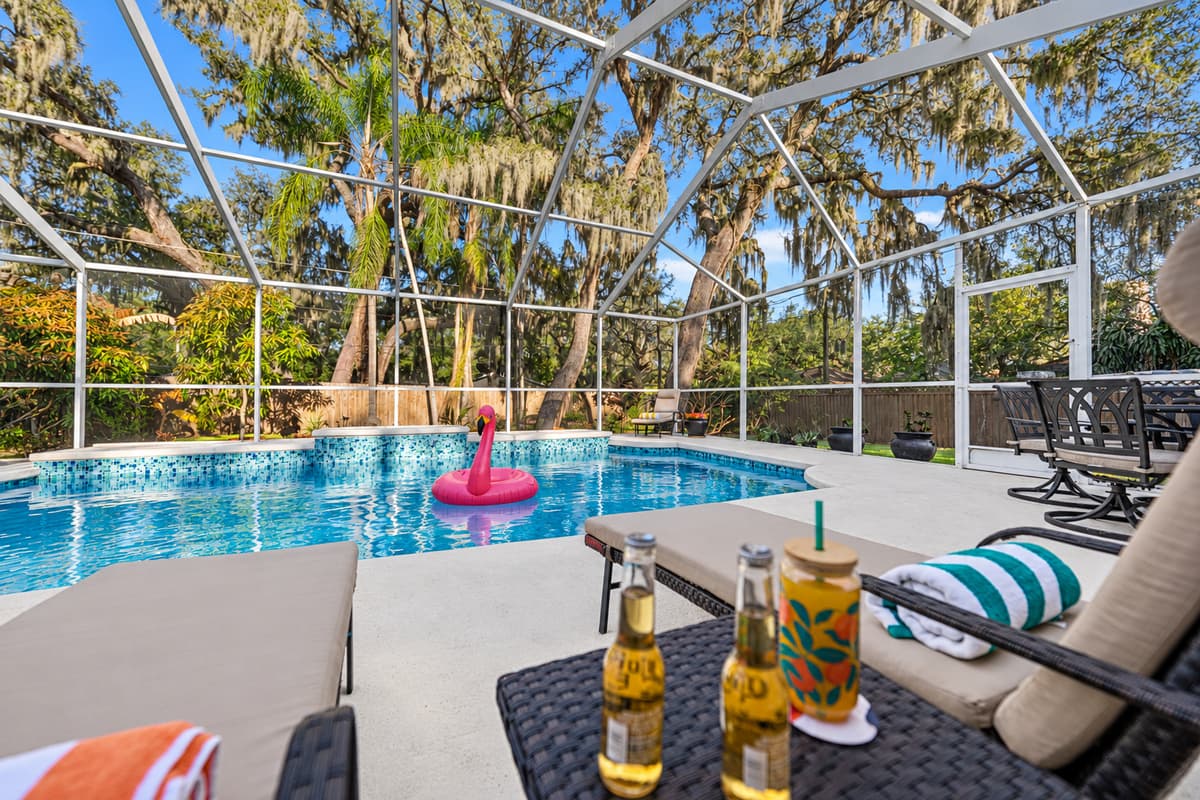 Unwind poolside with shaded lounge seating, creating the ultimate vacation atmosphere under the screened enclosure.