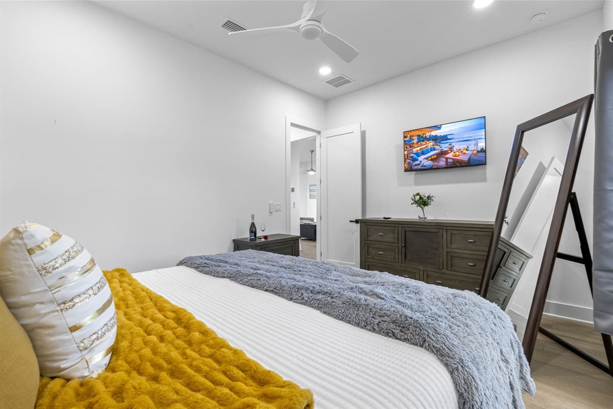 The decor of this queen bedroom exudes a warm and welcoming ambiance, featuring a harmonious blend of colors and textures.