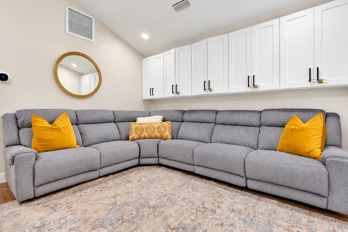 Seats the whole group without anyone perching. Enormous sectional under vaulted ceilings, with storage above and a screen in front — movie nights that don't leave four people standing.