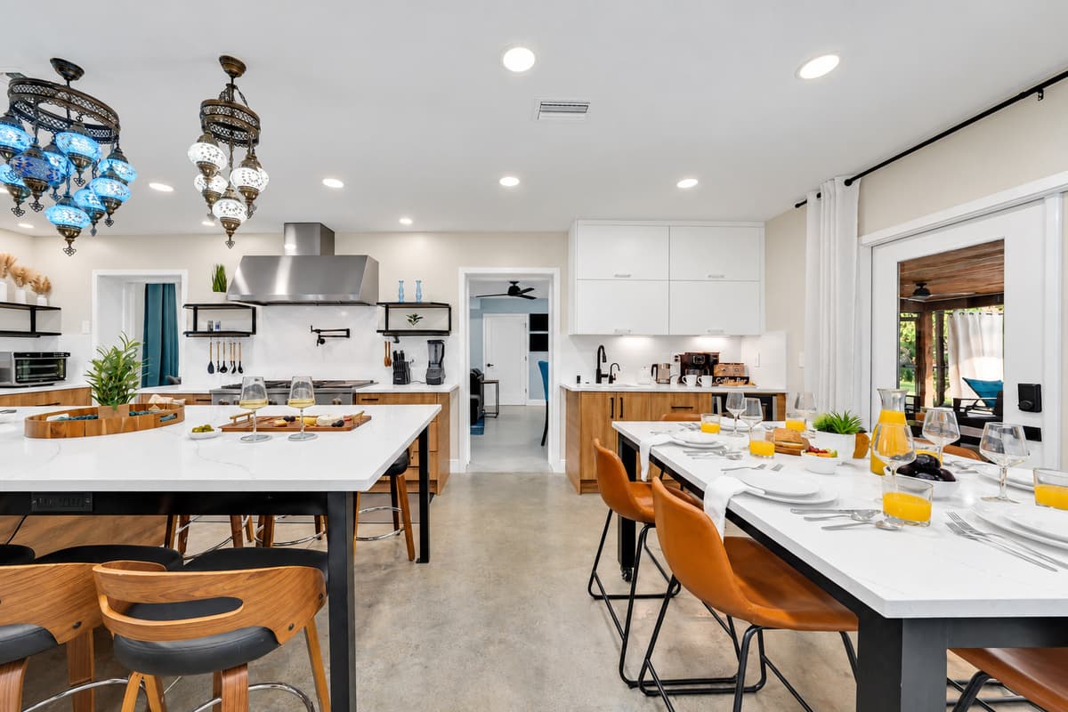 Two long counters, eighteen places, one meal. Prep on one island, serve on the other, seat the entire group without folding chairs or splitting anyone into a second sitting.