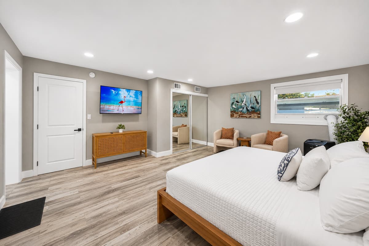 Oversized bedroom with TV, sitting area, dresser, and spacious layout designed for comfort and relaxation.