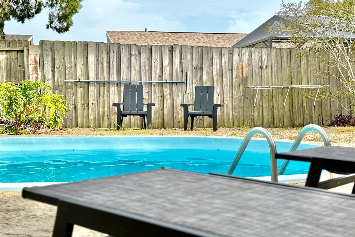 Enjoy alfresco vibes all day long in this sunny backyard—dip in the pool, kick back in the hammock, and end the night under the stars with your crew by the fire.