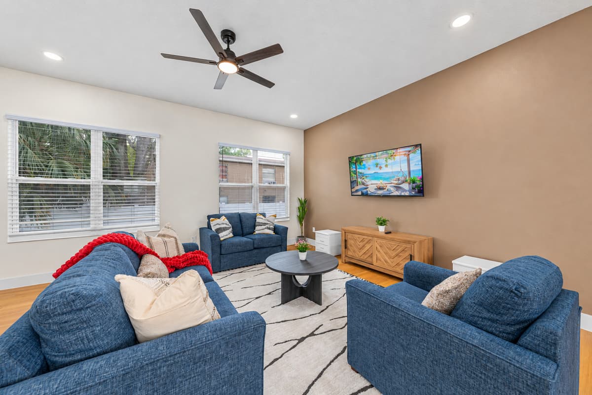 The spacious living room opens to a private patio through sliding glass doors, flooding the space with natural light.