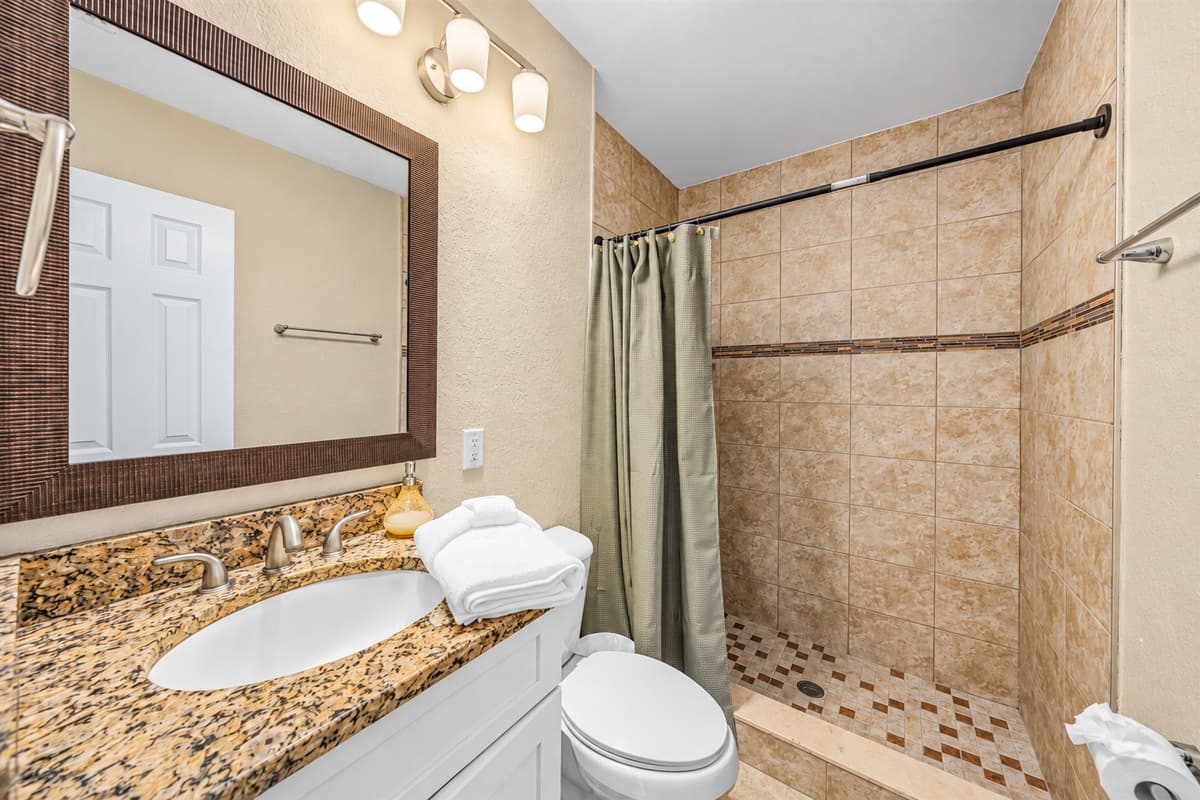 Stylish bathroom with tiled walk-in shower and modern finishes.