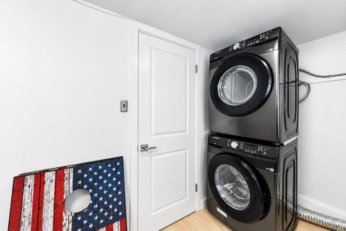 Convenient in-home laundry area featuring stacked washer and dryer for guest use.

