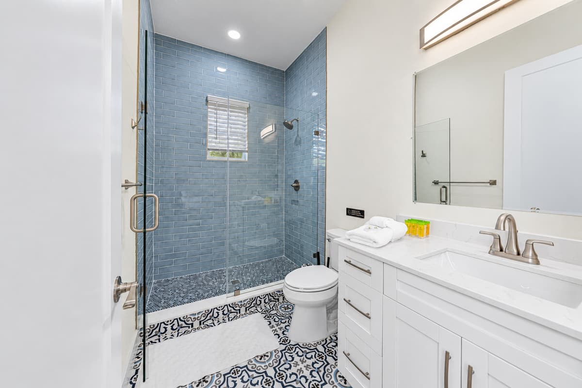 Bathroom 1 (en suite): glass walk-in shower with modern blue tile.