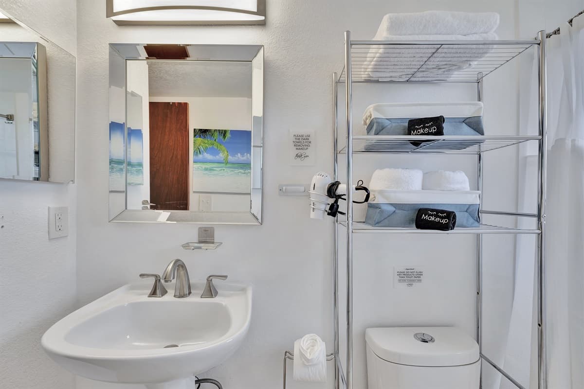 The sleek design of the vanity is complemented by a large, well-lit mirror, ensuring you have perfect lighting for your morning and evening routines.