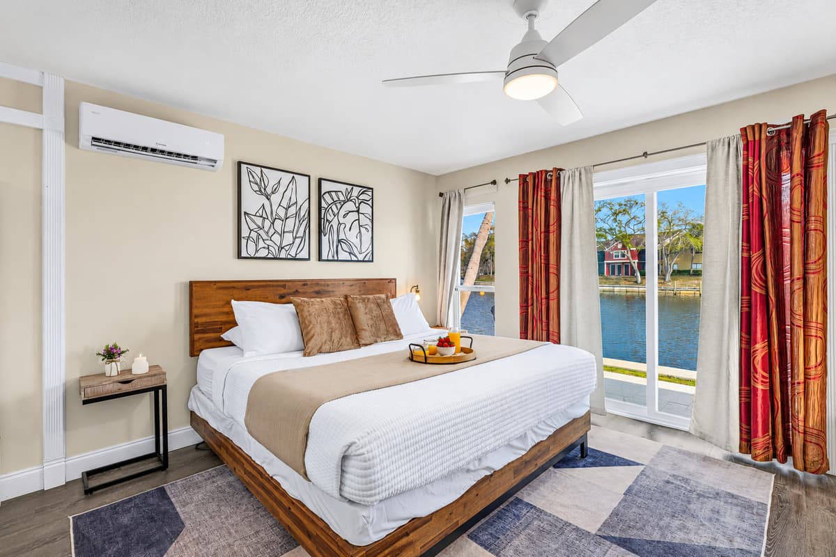 Spacious waterfront bedroom featuring a king bed and beautiful lake views.