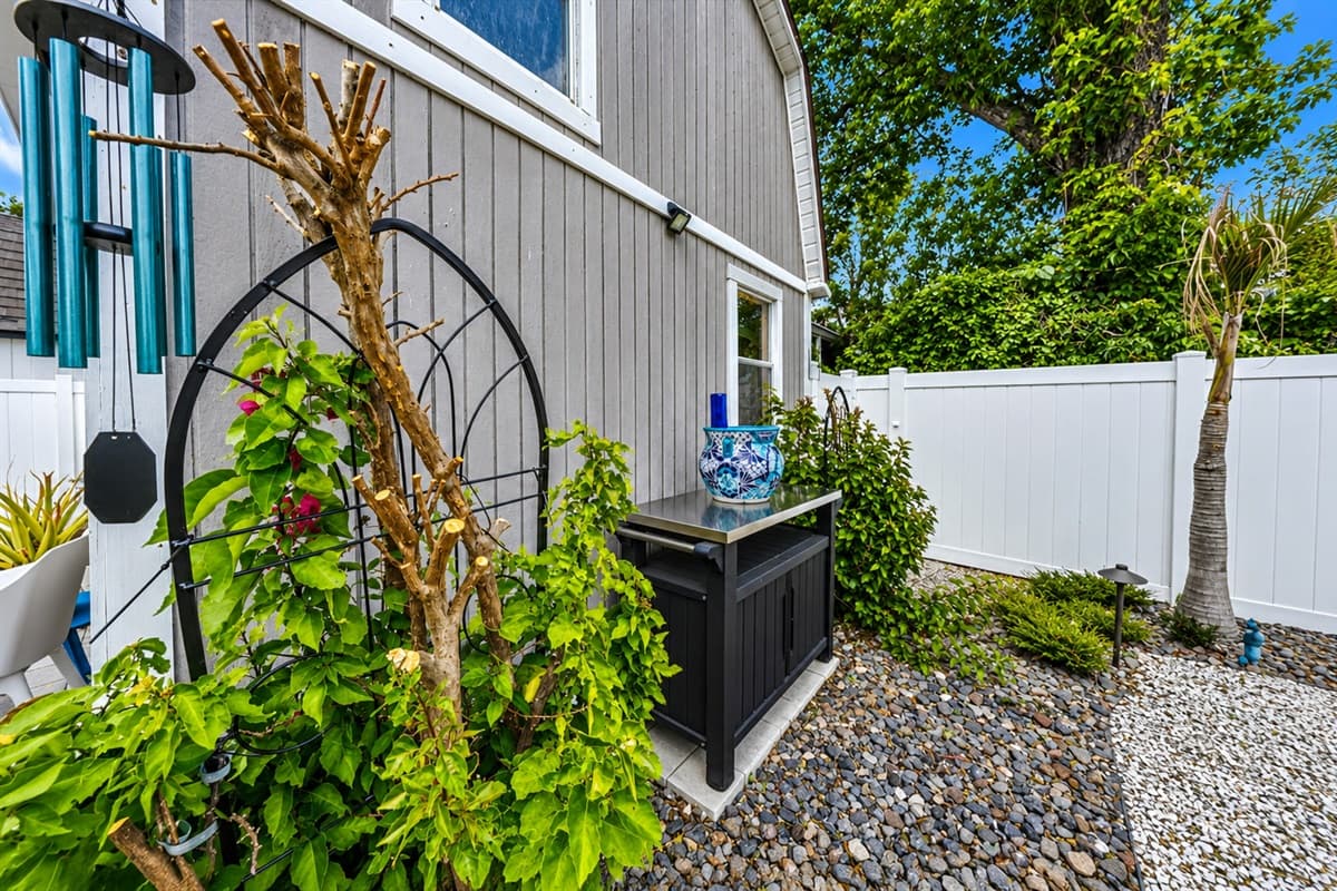 Beautifully landscaped outdoor corner with charming garden accents and backyard seating area.