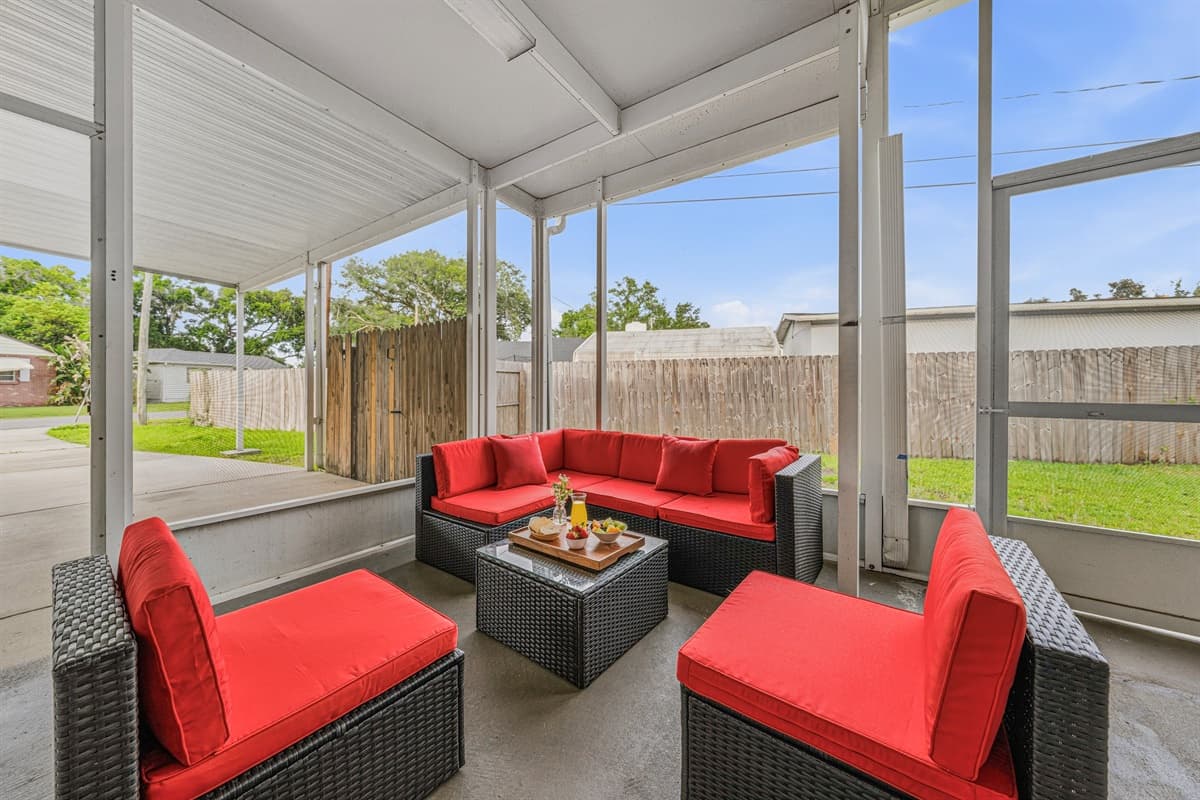 Screened-in patio with cozy seating and views of the private fenced backyard.