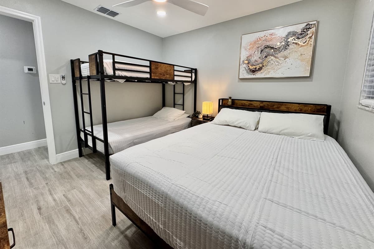 This bedroom features a queen-size bed and a bunk bed, offering flexible sleeping arrangements perfect for families or groups.