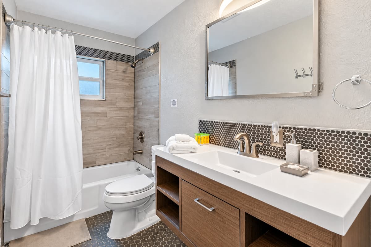 Clean and modern bathroom featuring a shower/tub combo and stylish finishes.