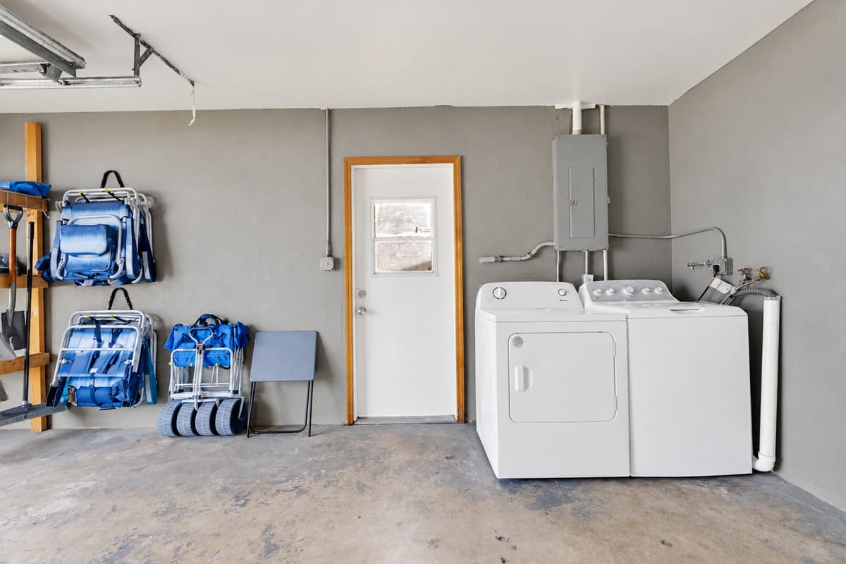 Full-size washer and dryer in the garage, with the beach gear parked right beside them. Wet towels go straight from the car to the machine, which is the only way a week with nine people stays manageable.