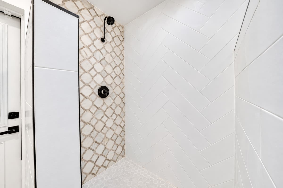 Patterned tile and a spacious shower. The walk-in shower in Bathroom 1 features decorative tile and modern black fixtures. A fresh rinse after a day outside.