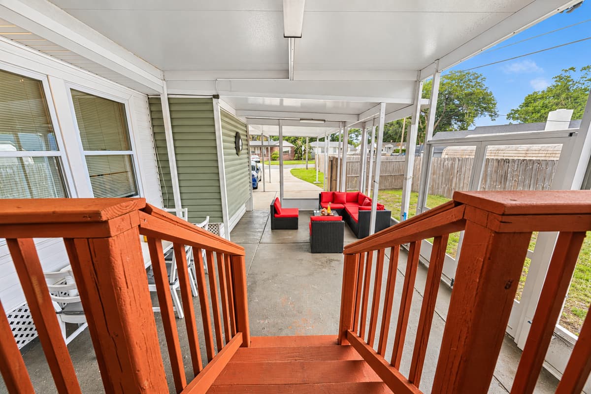 Entry view from patio steps leading into a large covered outdoor living space.