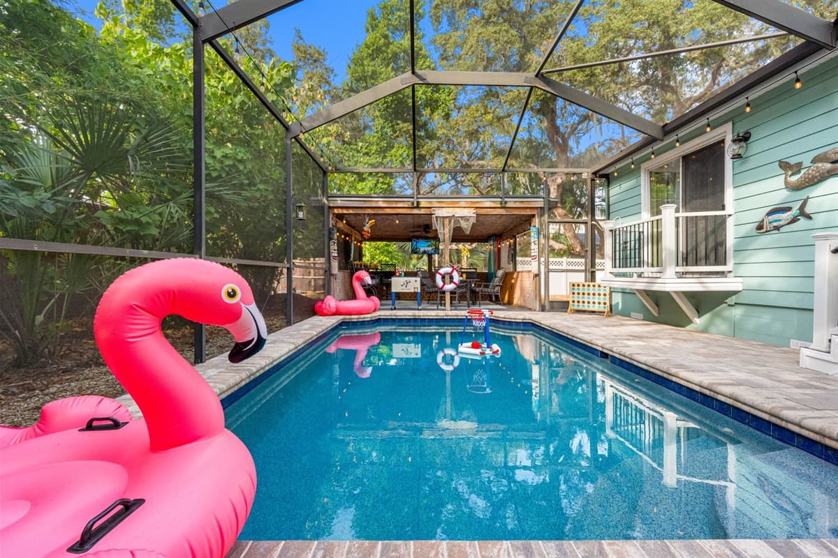 The pool area offers a serene retreat with lush landscaping, warm lighting, and a spacious deck ideal for lounging or swimming.