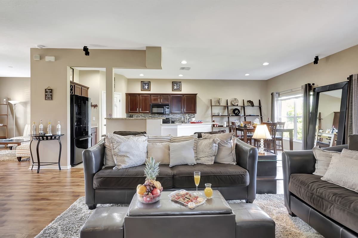 Our spacious living room beckons with a massive, plush grey sofa that practically envelops you in relaxation.