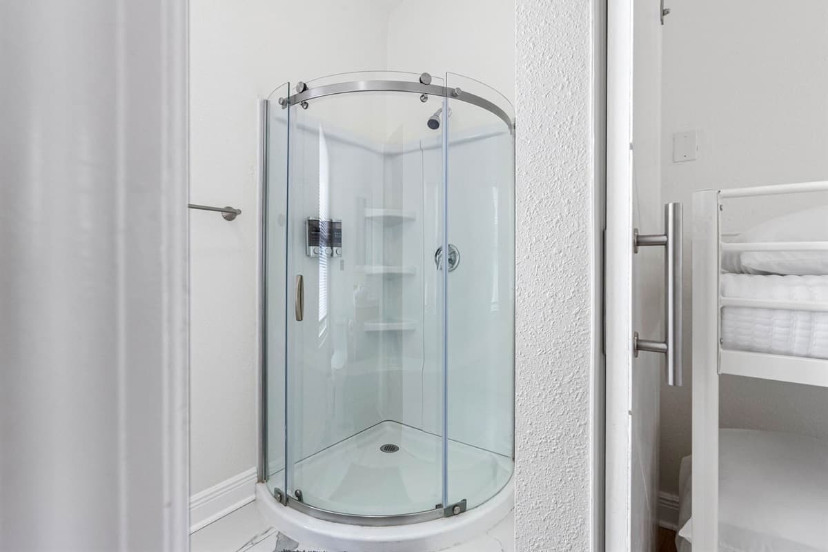 This ensuite bathroom offers a contemporary walk-in shower with curved glass, a stylish vanity, and neutral finishes that create a calm, spa-like atmosphere.