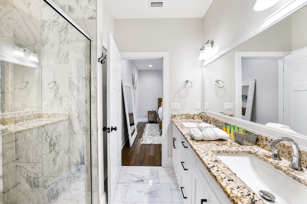 The spacious primary bathroom features a dual-sink vanity and a large walk-in shower with elegant finishes.