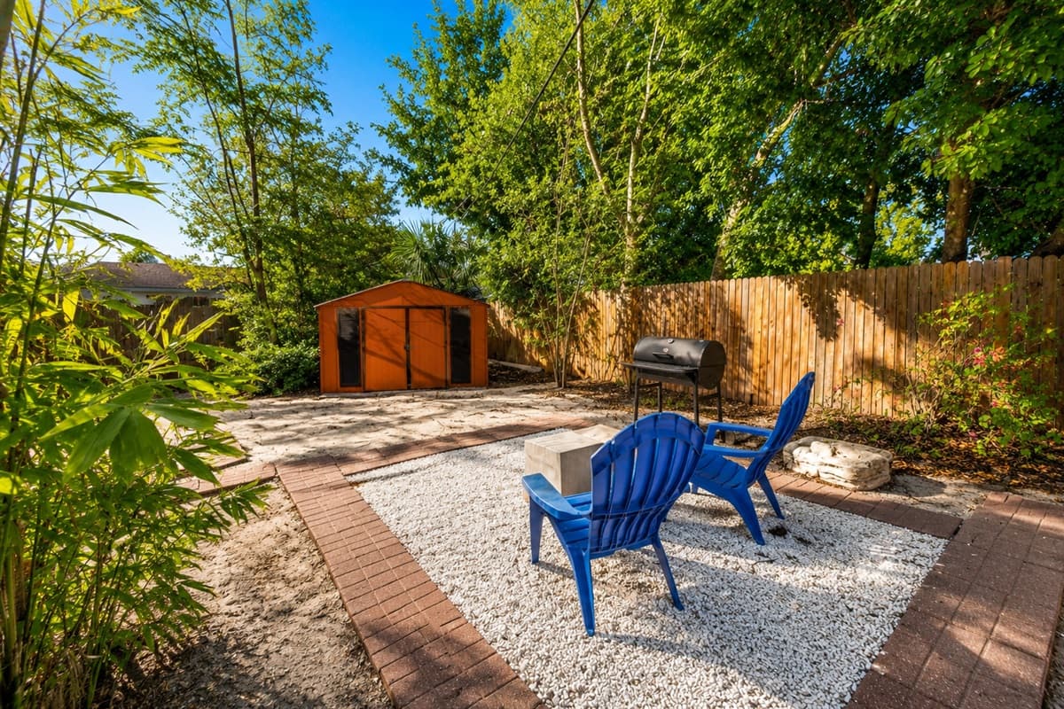 Relaxing backyard corner with cozy seating, mature trees, and a tranquil outdoor atmosphere.