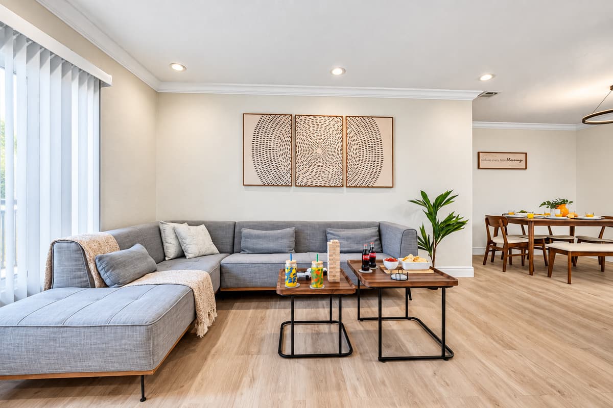 Perfect for movie nights or catching up with friends, this airy living room features wood floors, modern artwork, and a cozy vibe.