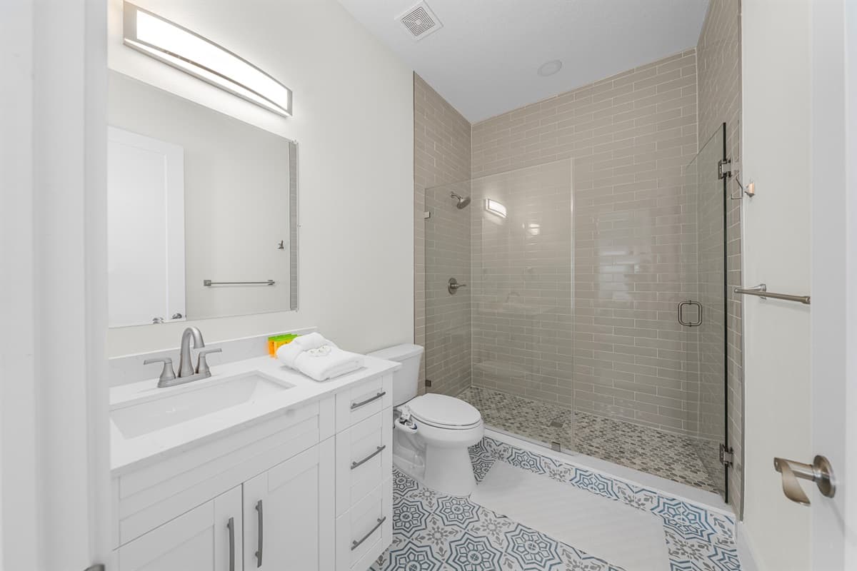 Spacious bathroom with glass shower and contemporary finishes.
