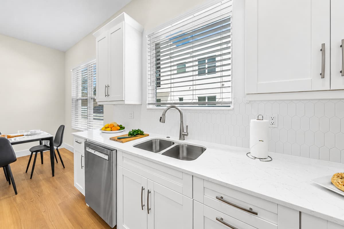 Bright, modern kitchen with crisp white countertops, ample cabinet space, and stainless steel appliances.