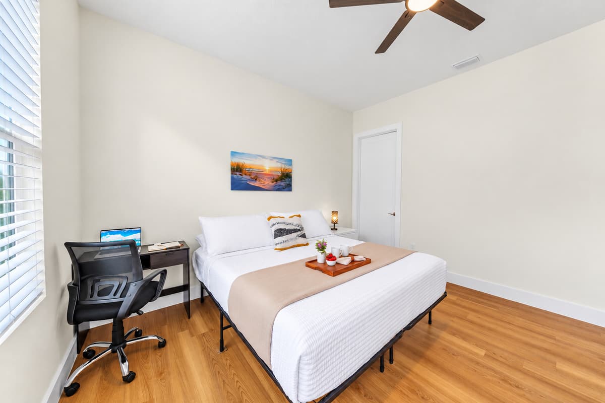 Comfortable bedroom with workspace and cozy setup for relaxation or productivity.