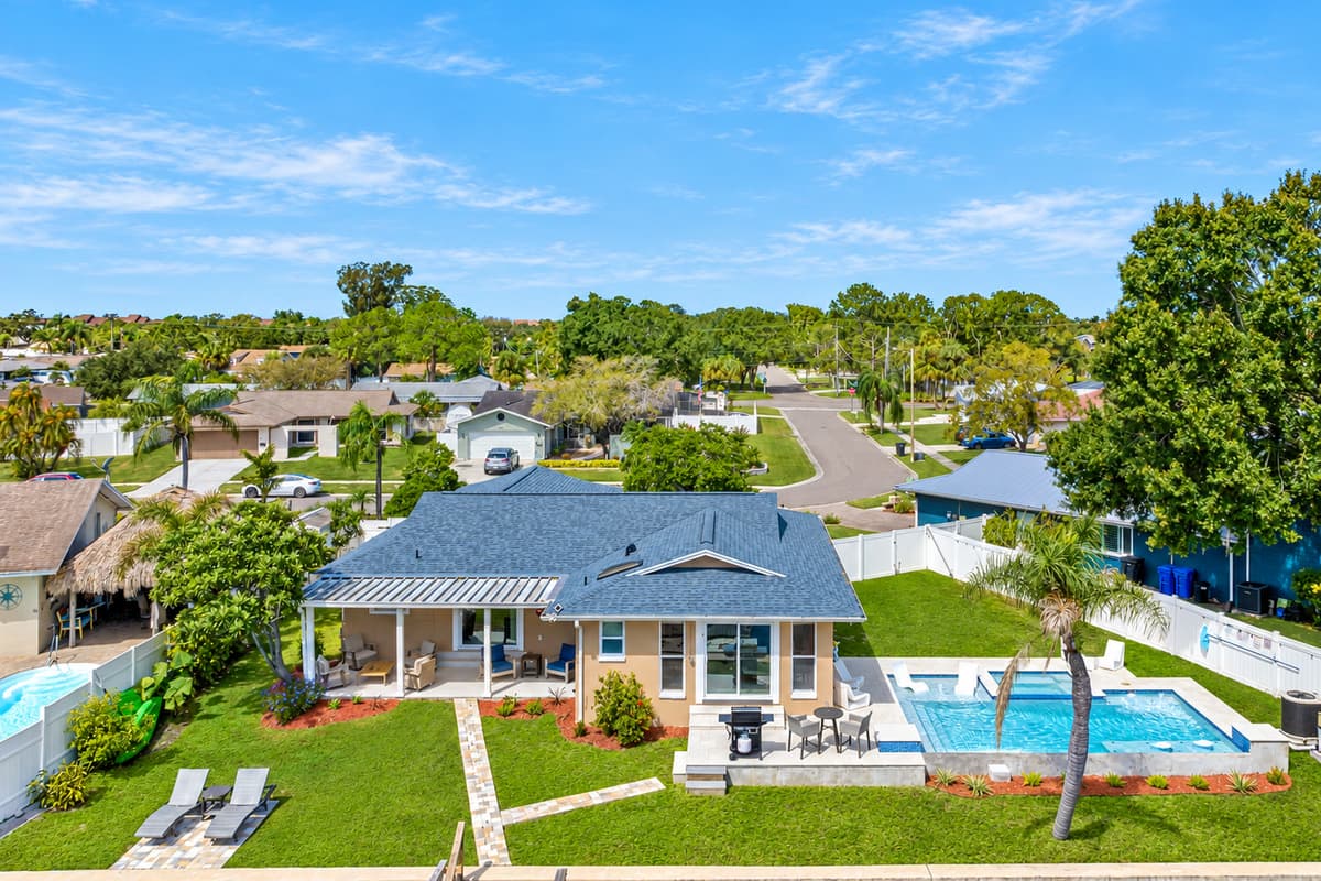 Aerial back view of our beautiful house showcasing our stunning heated pool. The property has some trees and has a fenced backyard. If you are interested in this property, send us an inquiry now!