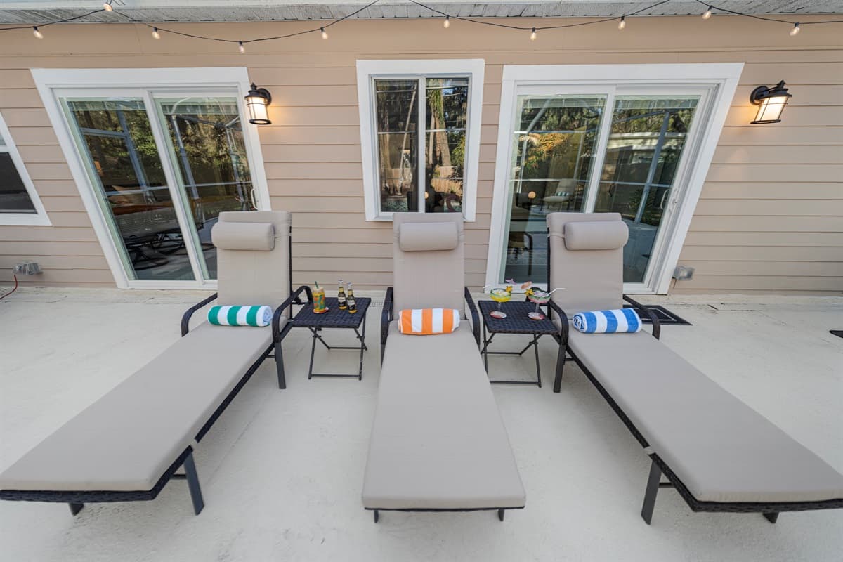 This serene pool area offers a relaxing retreat with comfortable loungers and a spacious screened enclosure.