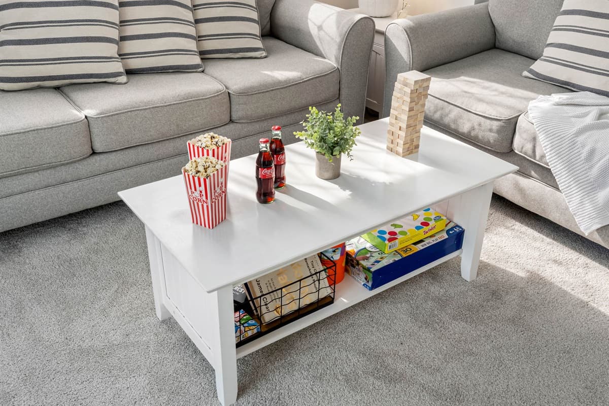 With its contemporary furniture, soft carpeting, and airy design, this living room offers both style and comfort for every guest.