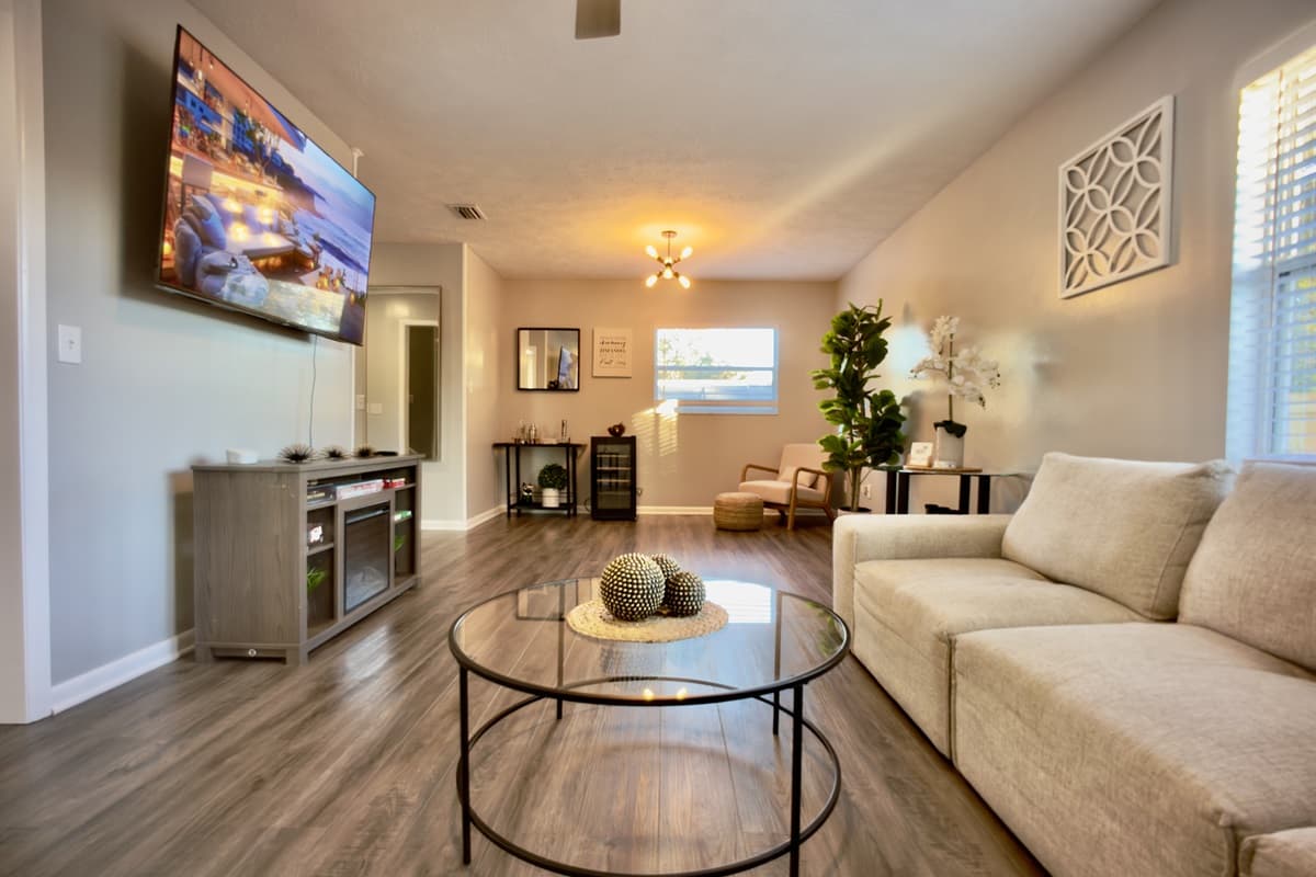 📺 The open-concept living area is designed for quality time together! Featuring a massive smart TV, stylish entertainment center, comfy sofa, and chic décor — your perfect gathering space. ✨🏠