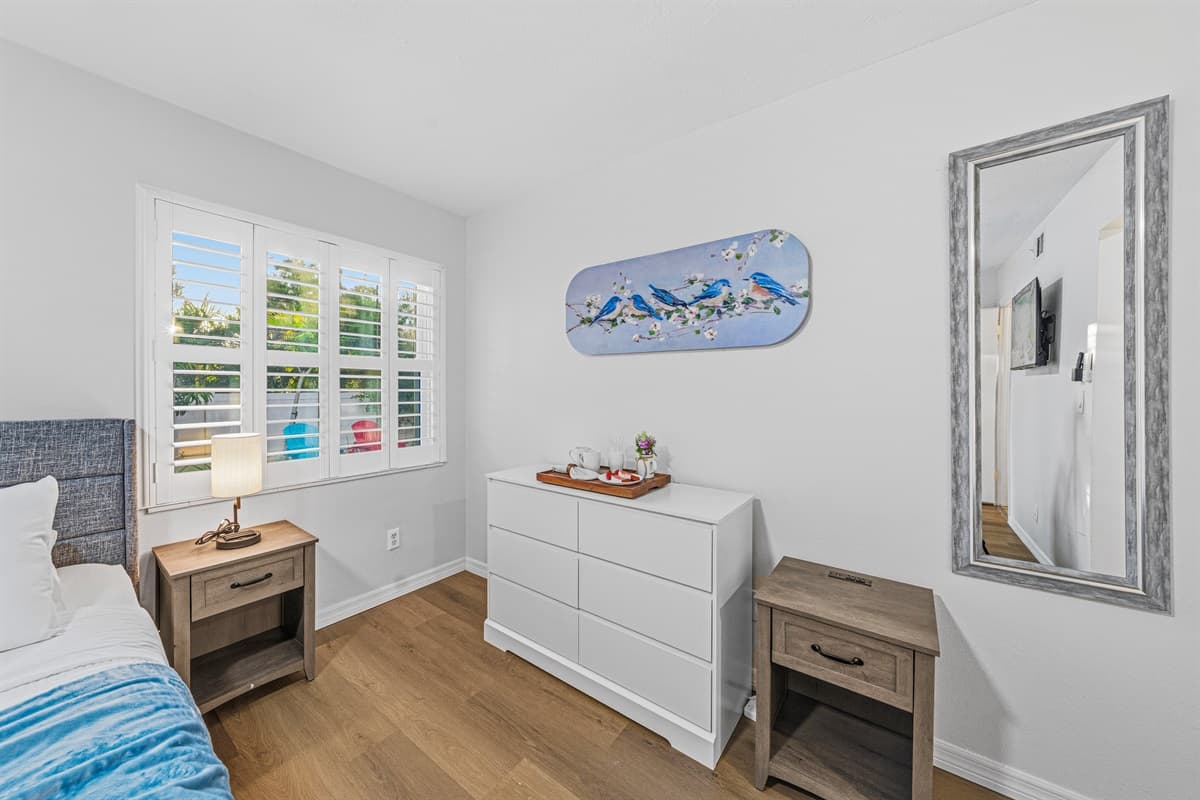Well-lit bedroom with stylish furnishings, ample storage, and a relaxing, minimalist design 