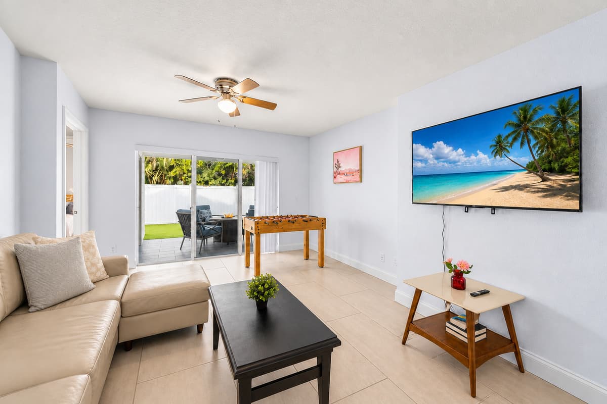 Inviting living room with large smart TV, natural light, and direct patio access.