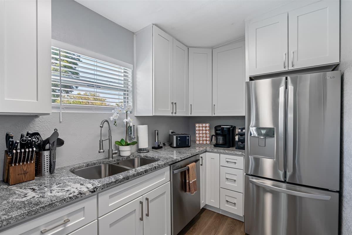 The sleek grey and black appliances add a modern touch and create a beautiful contrast against the white backdrop.