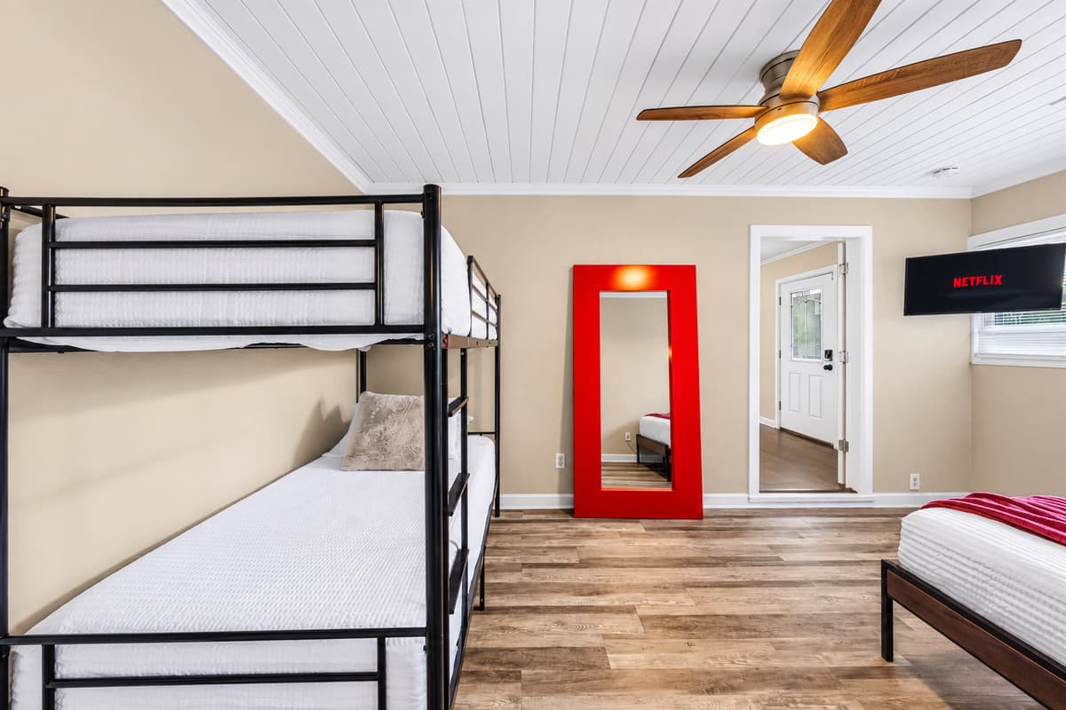 Large bunk room with ample sleeping space, TV, and fun setup for group accommodations.
