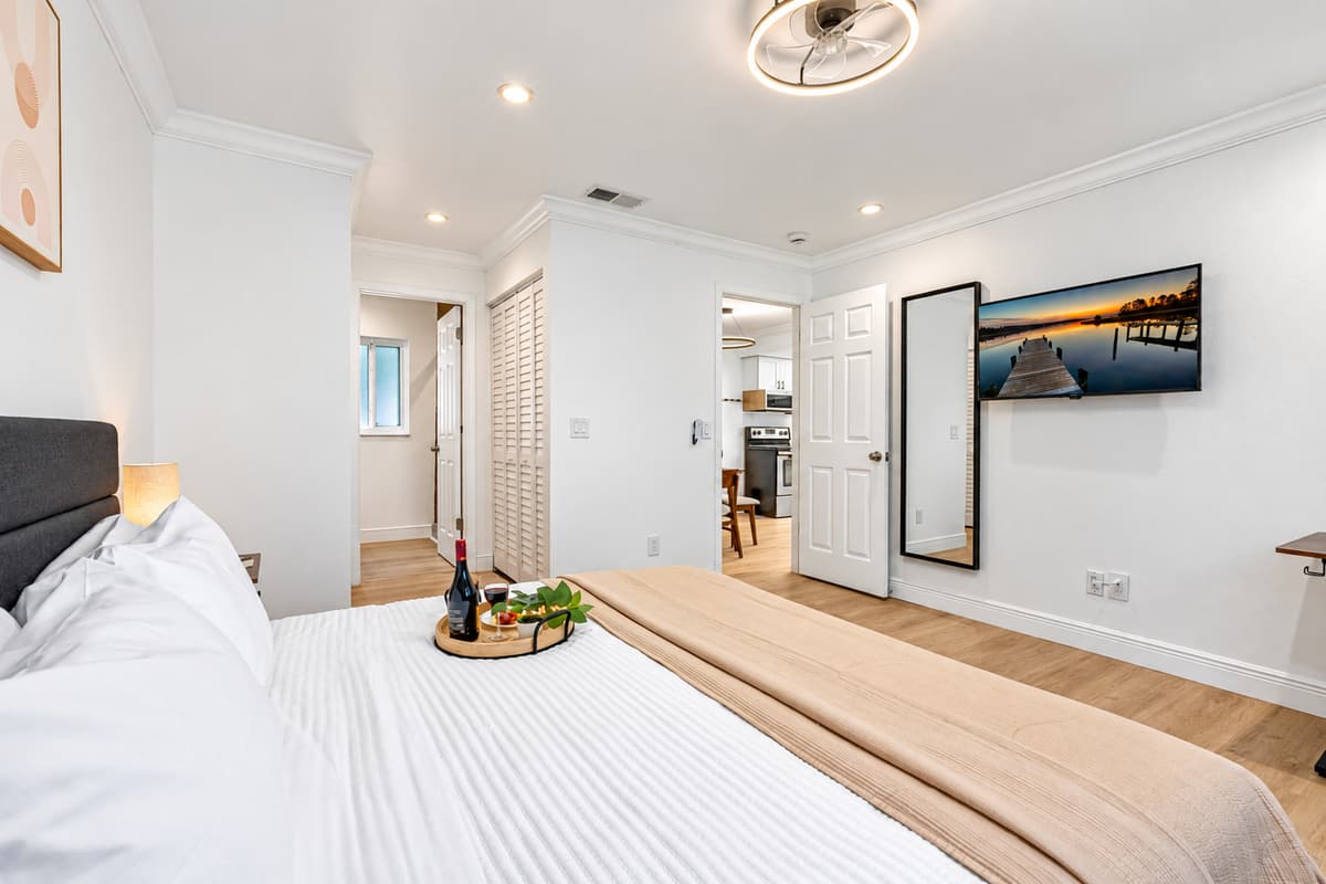 Enjoy movie nights from bed with the wall-mounted smart TV and blackout curtains for the ultimate binge-worthy setup.