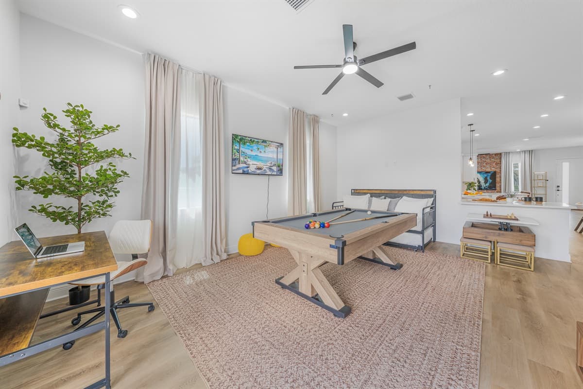 Multi-purpose game and workspace area with a pool table, desk setup, and comfortable layout for both fun and productivity.