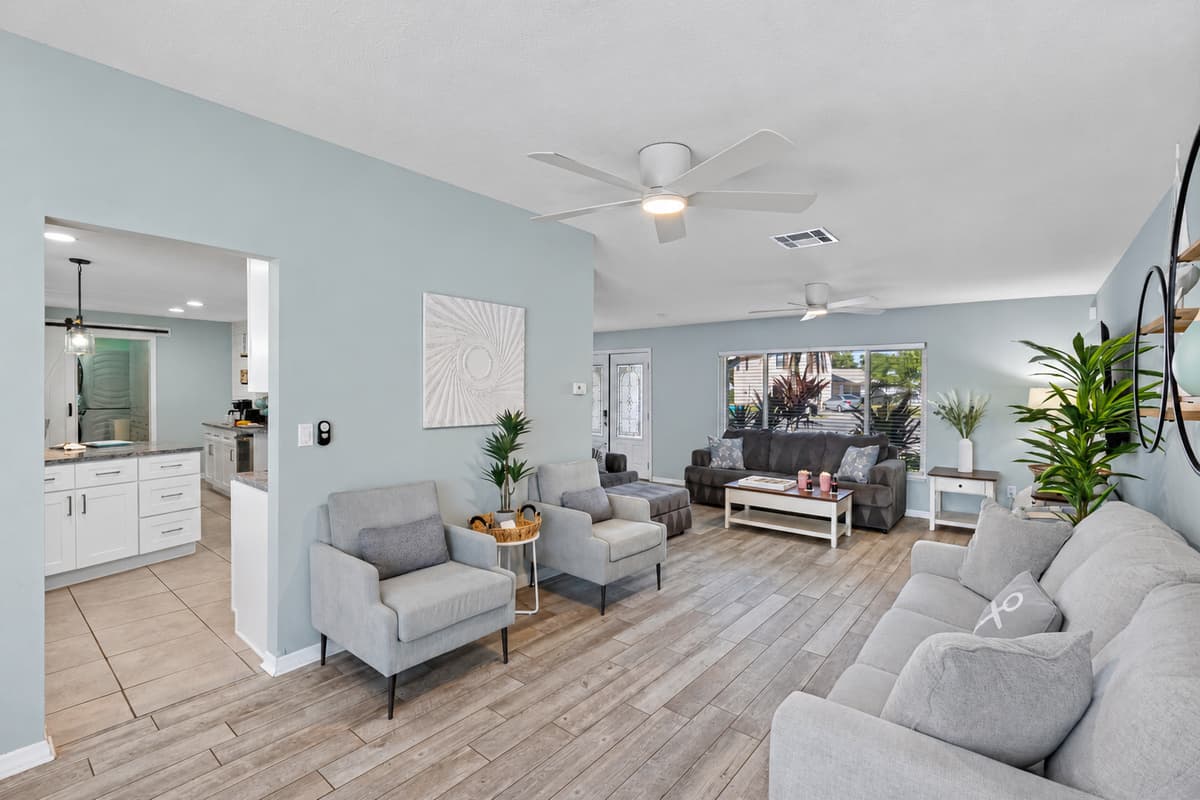 This open-concept living room offers plenty of seating, natural light, and direct access to the pool area for easy indoor-outdoor living.