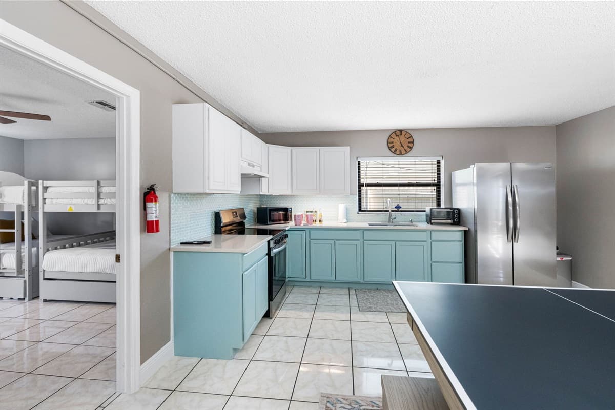 Soothing two-tone cabinetry in crisp white and soft seafoam green gives this kitchen a light, airy feel.