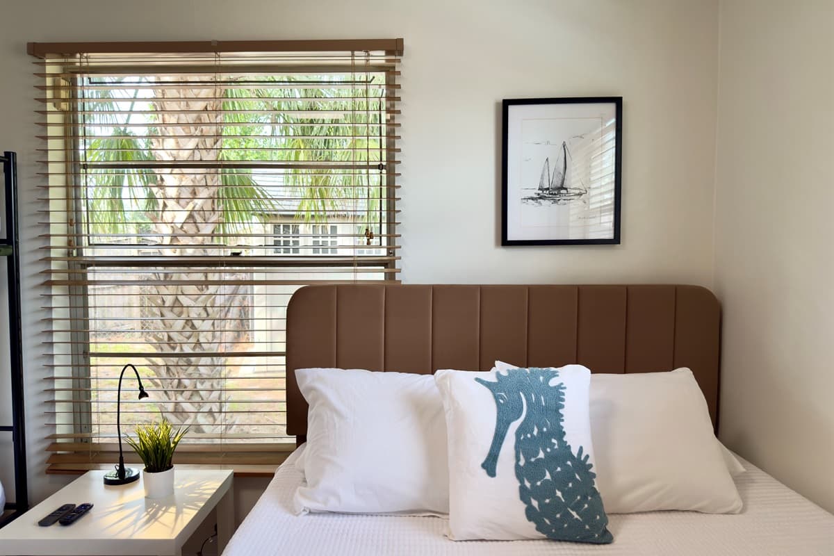 Uncluttered and serene, this bedroom features a queen-size bed, a bunk bed, neutral palette, and modern lighting—designed for stress-free relaxation and quality sleep.