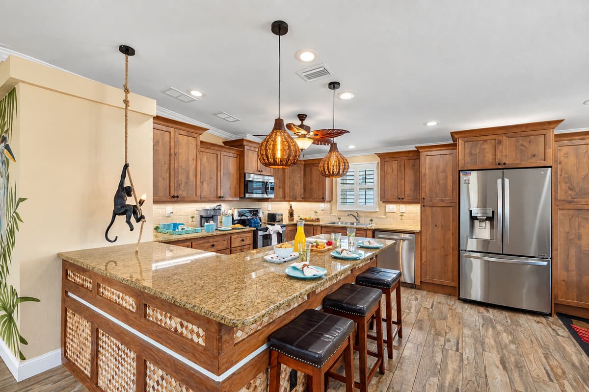 A bright and inviting kitchen, equipped with everything you need: coffee bar, cookware, breakfast bar seating, and premium appliances.