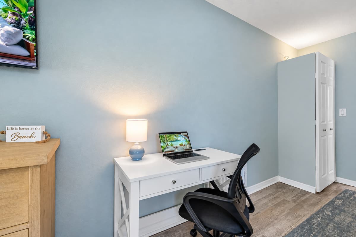 Bright and airy king bedroom featuring a sleek ceiling fan, work desk, and ensuite access — the perfect space to recharge.