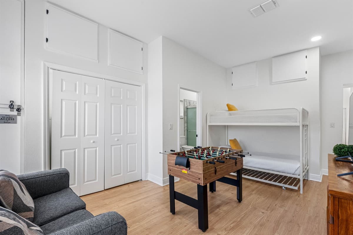 This spacious room blends comfort and fun, featuring twin bunk beds, a foosball table, and a large TV—perfect for kids, teens, or group entertainment.